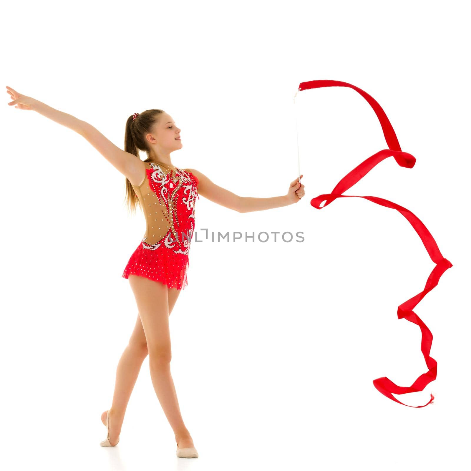 Little girl gymnast performs exercises with tape. The concept of sport, competition. Isolated on white background.