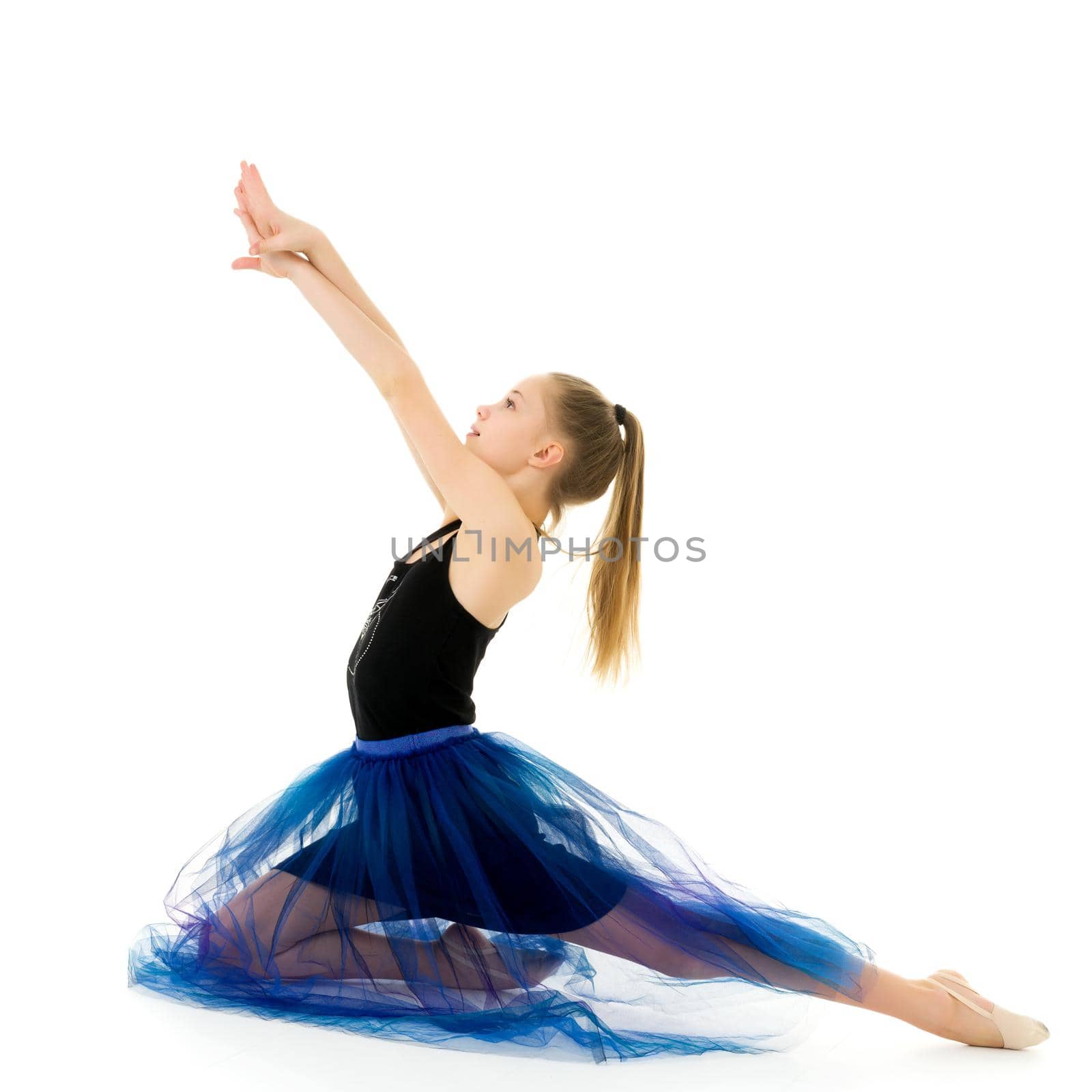 Lovely Blonde Girl Wearing Stylish Tulle Dress Sitting on the Floor on her Knees Against White Background, Adorable Long Haired Girl in Fashionable Bright Clothes Posing in Front of Camera in Studio