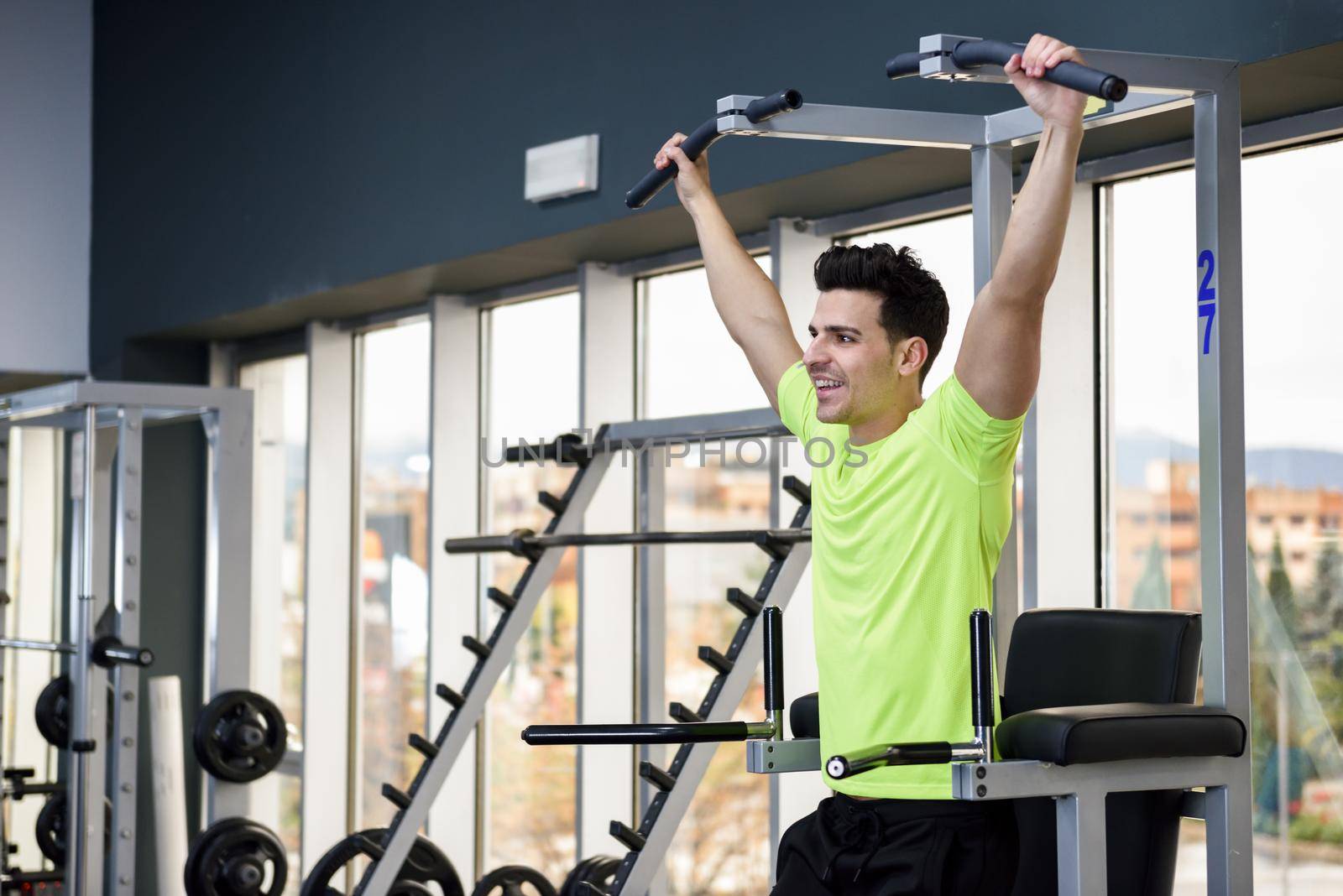 Young fit man wearing sportswear training at the gym. Healthy lifestyle and fitness concept.
