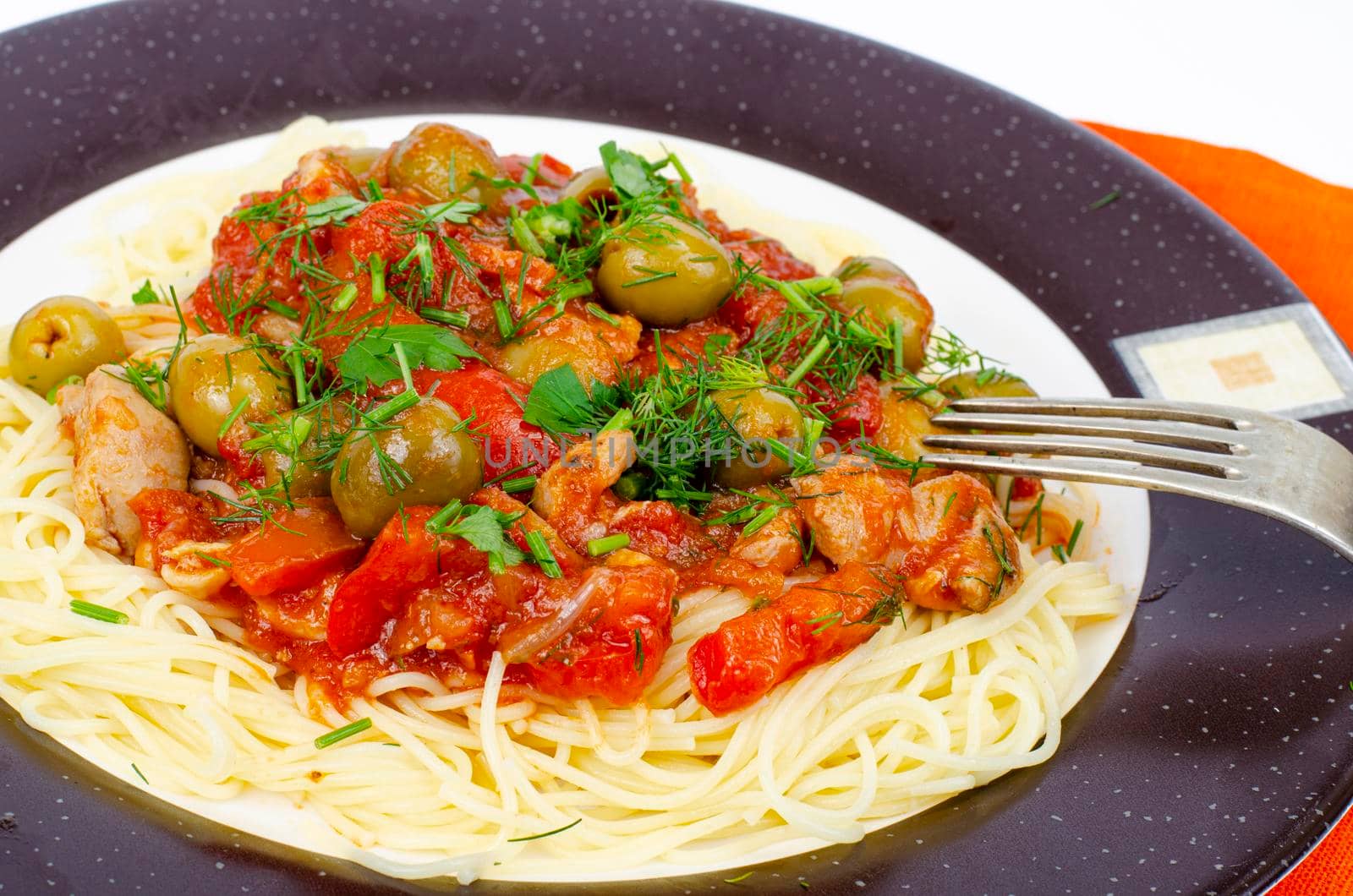Spaghetti with stewed vegetables and green olives. Studio Photo.