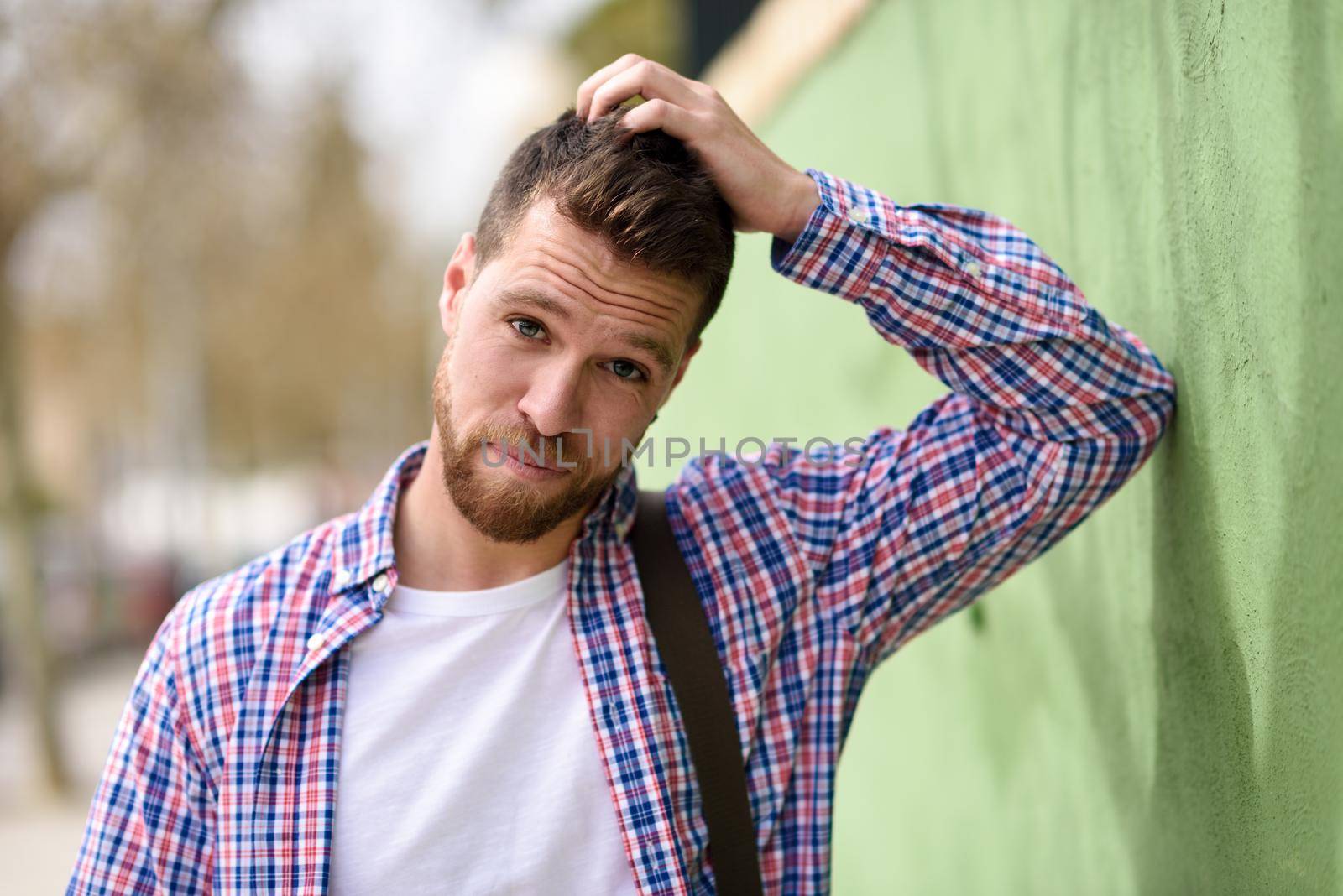 Attractive young man standing in urban background. Lifestyle concept. by javiindy