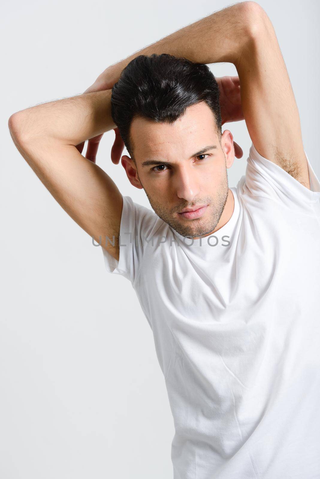 Portrait of a smart serious young man standing against white background
