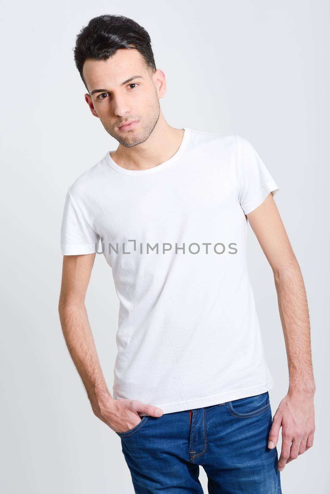 Portrait of a smart serious young man standing against white background