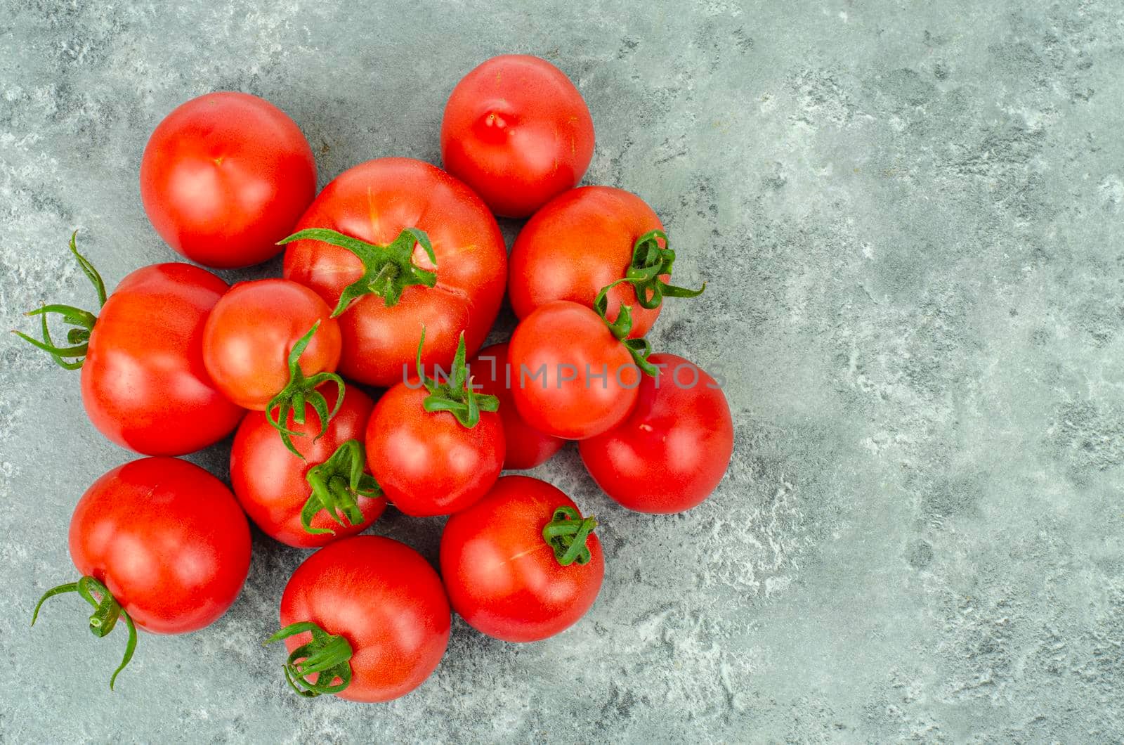 Bunch of ripe tomatoes on blue-gray background. Studio Photo.
