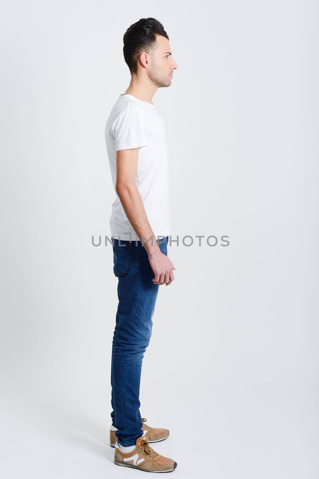 Portrait of a smart serious young man standing against white background