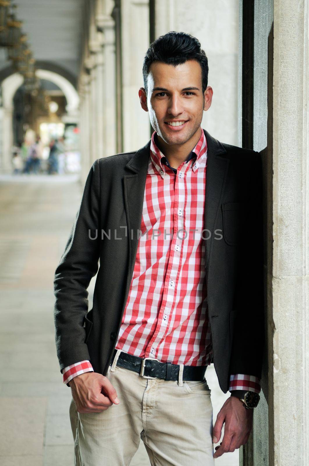 Portrait of a young handsome man, model of fashion, wearing jacket and shirt in urban background