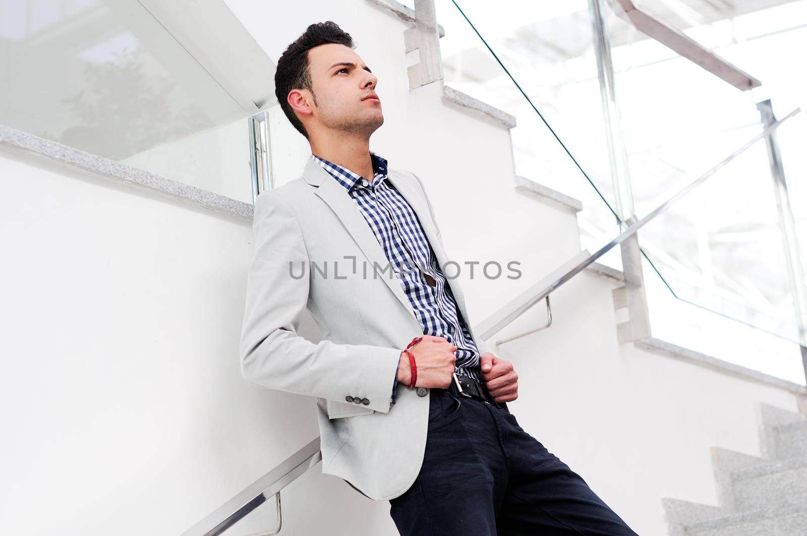 Portrait of a young handsome man, model of fashion, wearing jacket and shirt in urban background