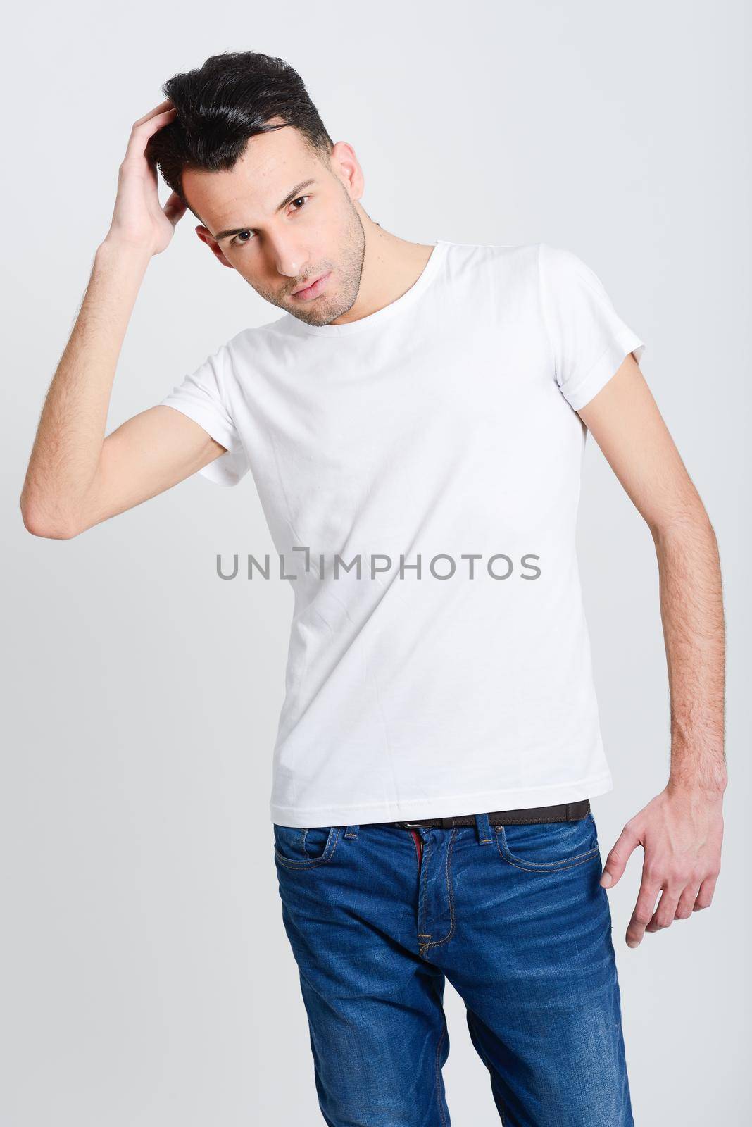 Portrait of a smart serious young man standing against white background