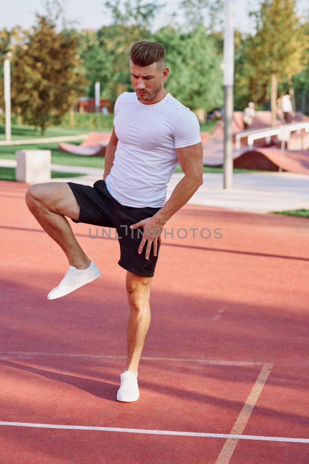 athletic men doing exercises on the sports ground in summer. High quality photo
