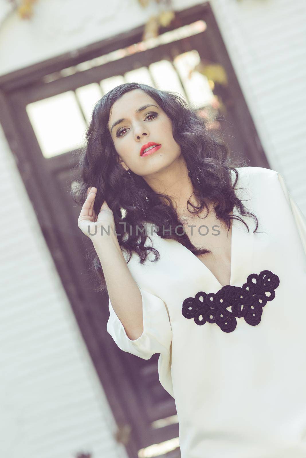 Portrait of beautiful woman, model of fashion, wearing white dress with curly hair