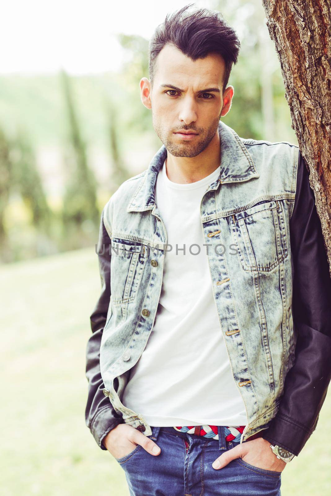 Portrait of a young handsome man, model of fashion, with modern hairstyle in urban background