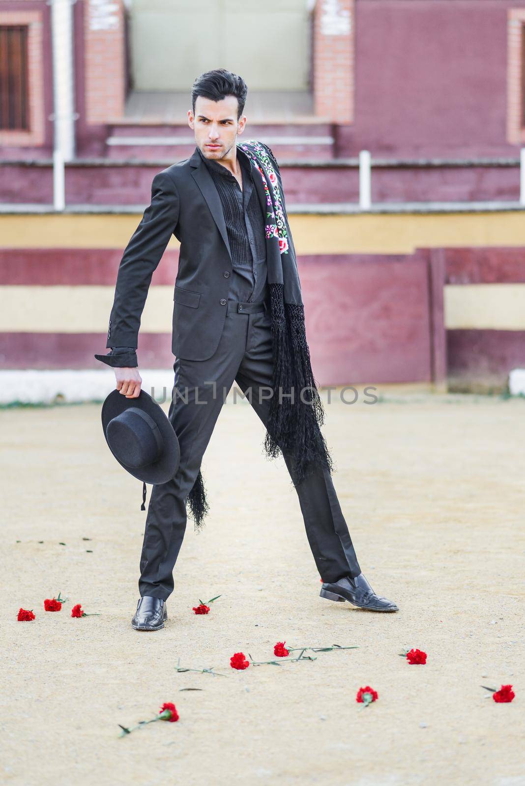 Portrait of a handsome man, model of fashion, wearing spanish clothes in a bullring