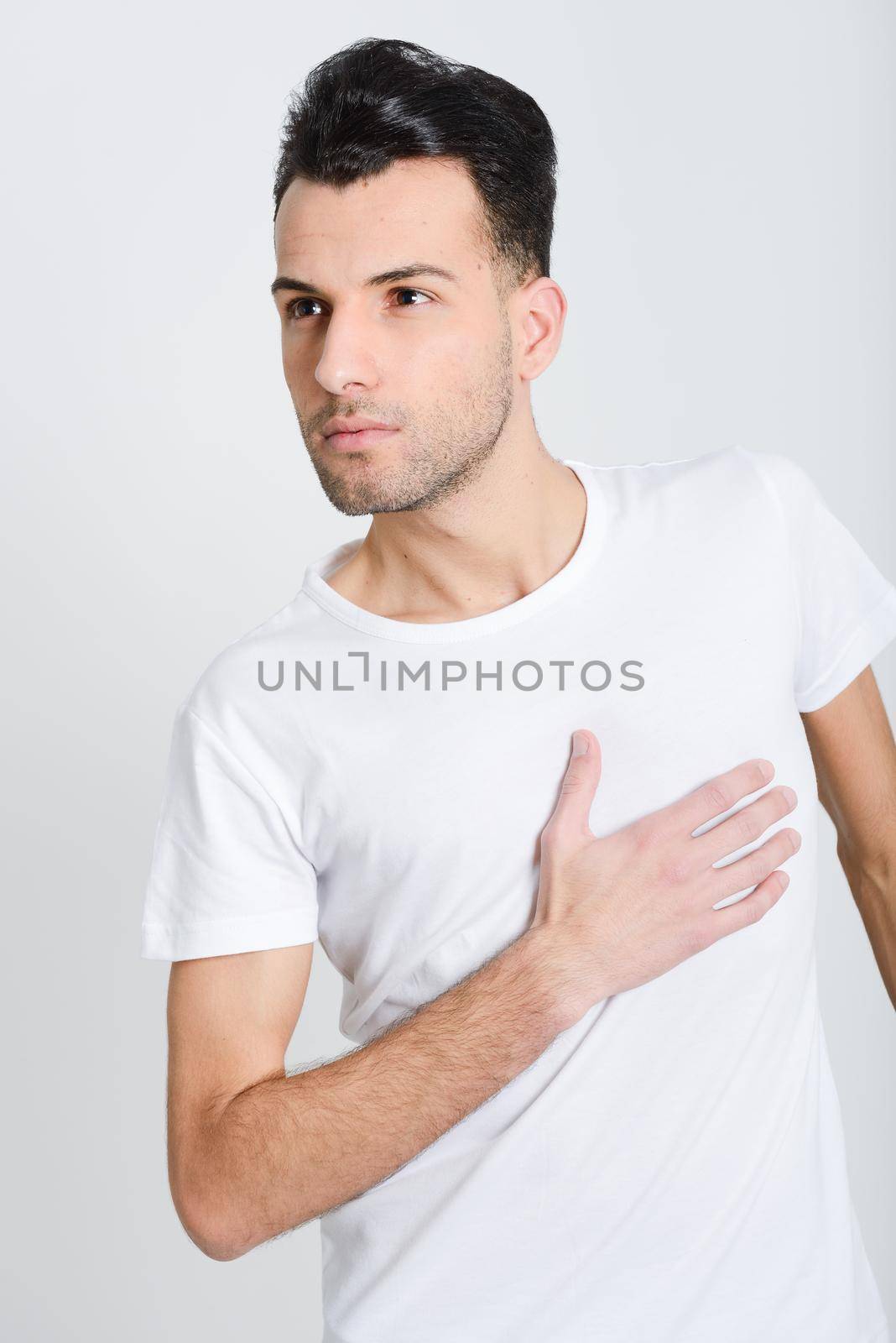 Portrait of a smart serious young man standing against white background