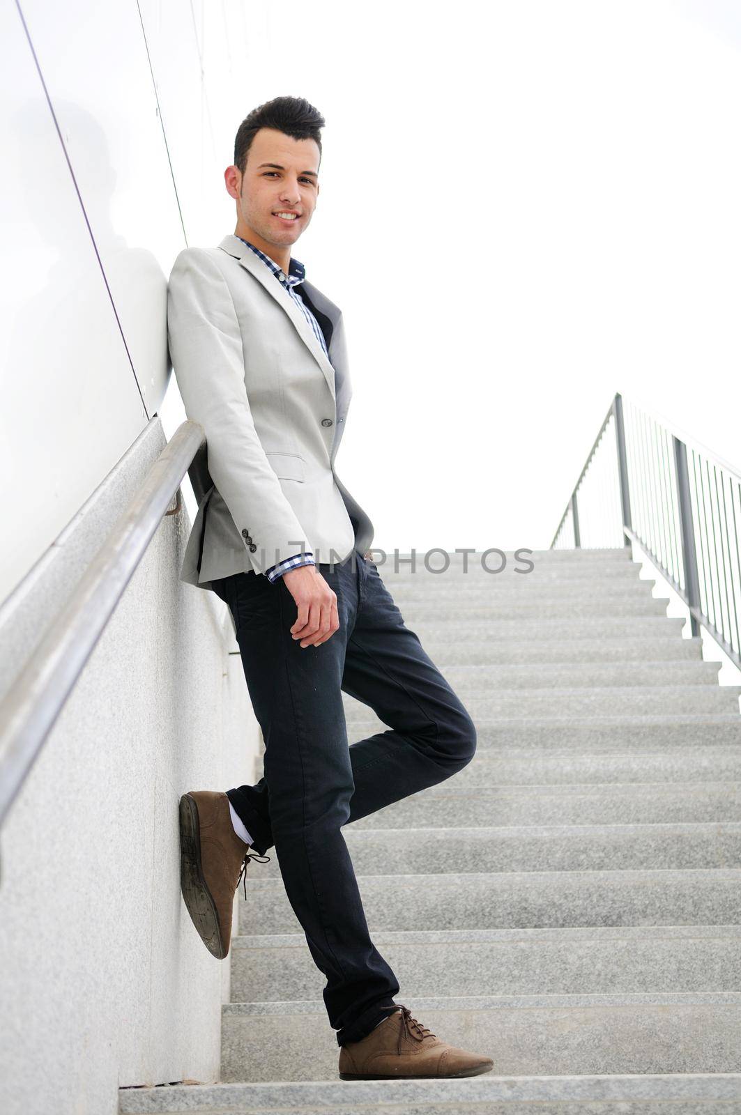 Portrait of a young handsome man, model of fashion, wearing jacket and shirt in urban background