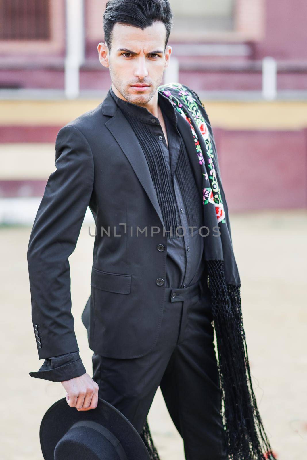 Portrait of a handsome man, model of fashion, wearing spanish clothes in a bullring