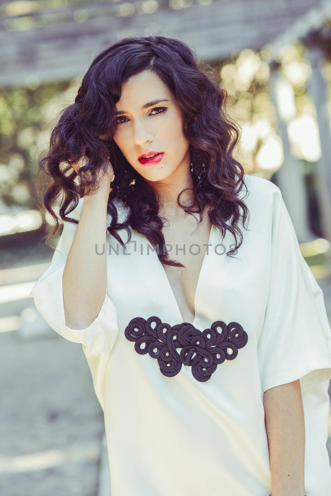 Portrait of beautiful woman, model of fashion, wearing white dress with curly hair