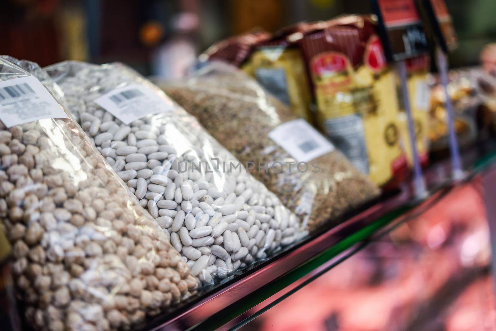 Bags of dried legumes and spices for sale in a store