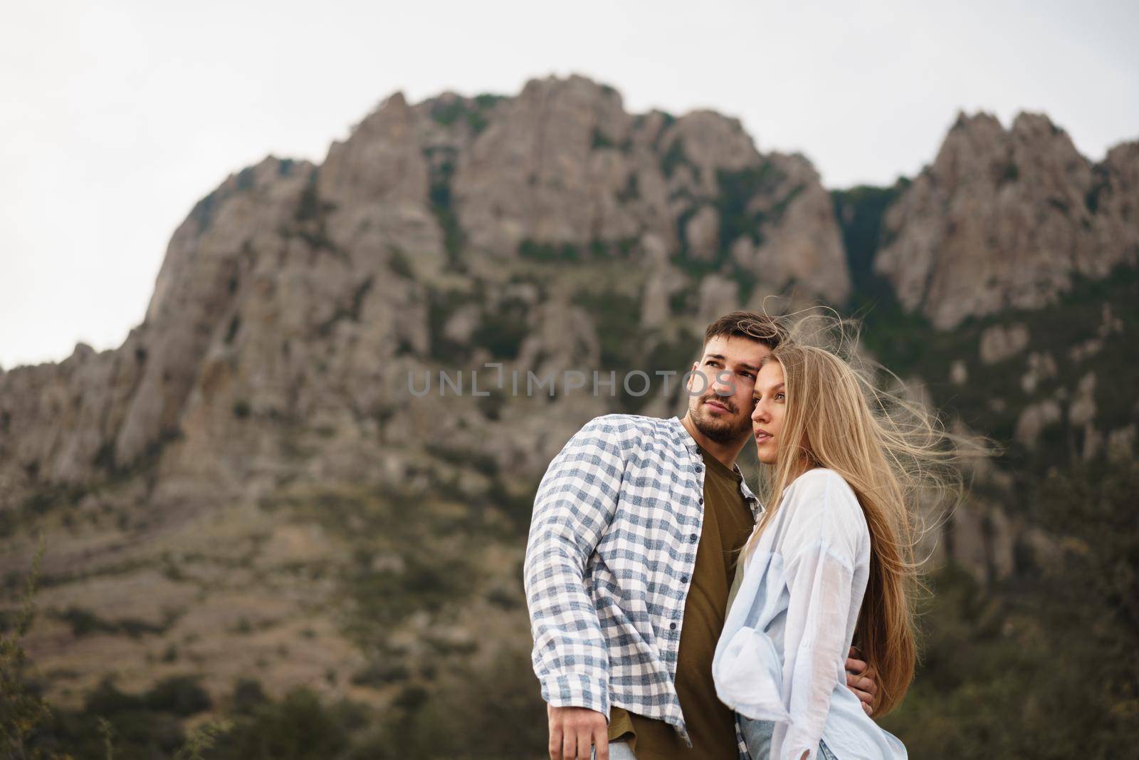 Happy loving couple hiking and hugging in mountains, close up