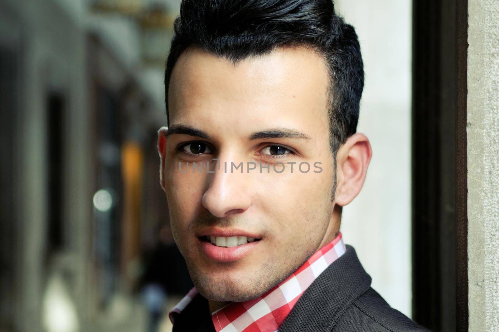 Portrait of a young handsome man, model of fashion, wearing jacket and shirt in urban background