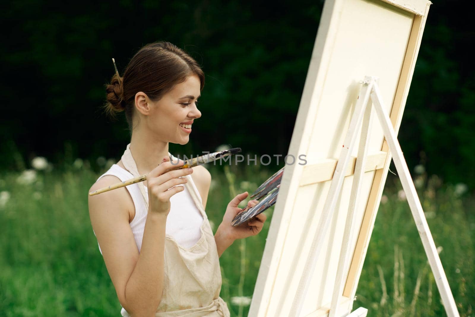 cheerful woman artist painting a picture outdoors creative art. High quality photo