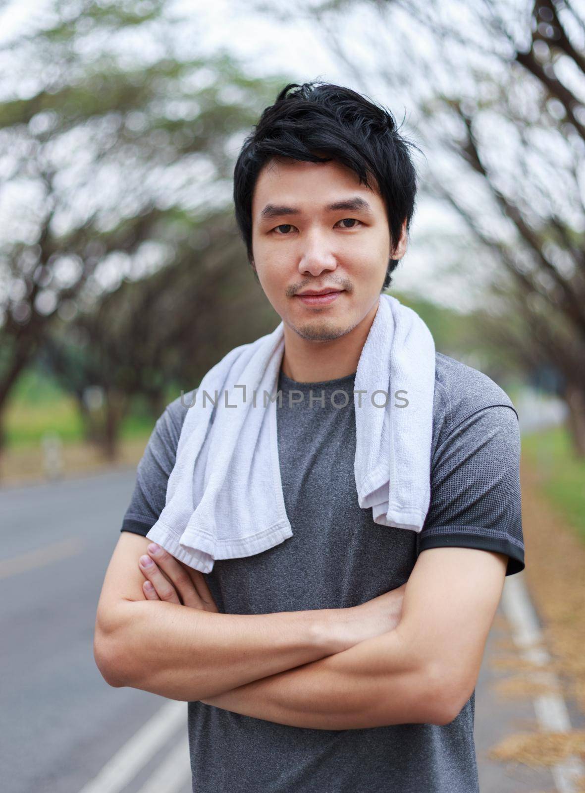 sporty man with arms crossed in park by geargodz