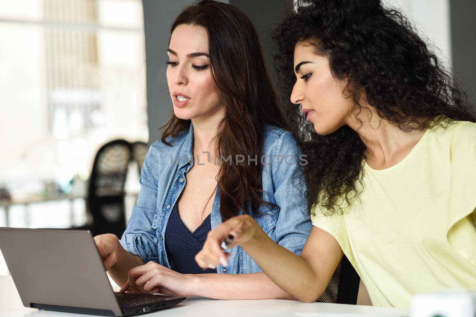 Two young women studying with a laptop computer. by javiindy