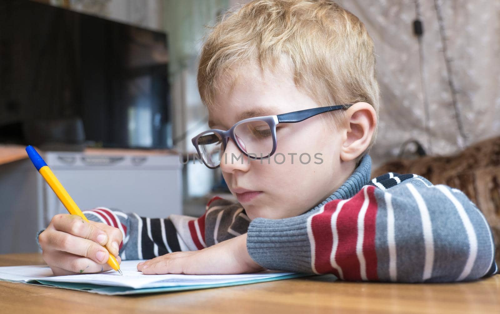 Focused first grader learning to write and doing homework.