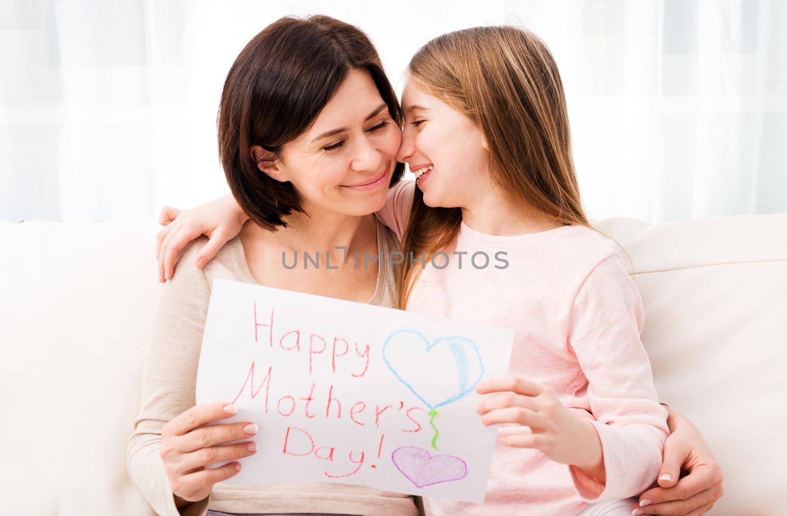 Little girl hugging her mother and holding greating card by GekaSkr