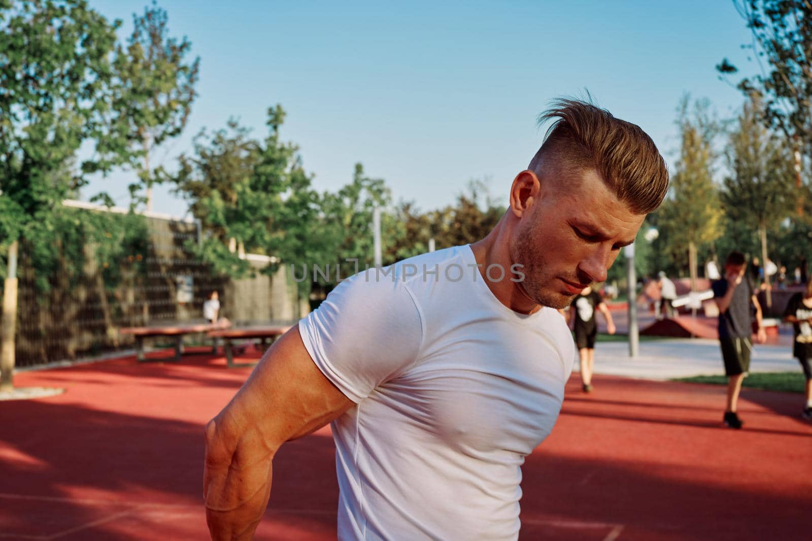 man doing exercises outdoors on the playground by Vichizh