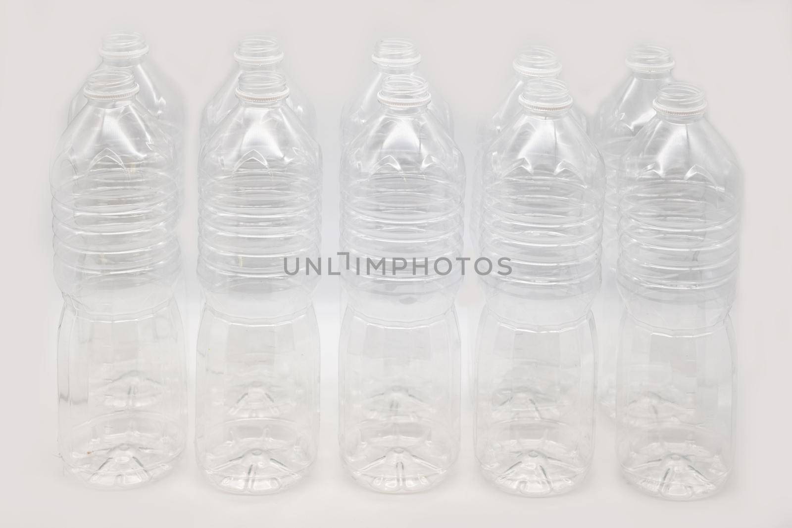 Row of plastic mineral water bottles isolated on a white background.
