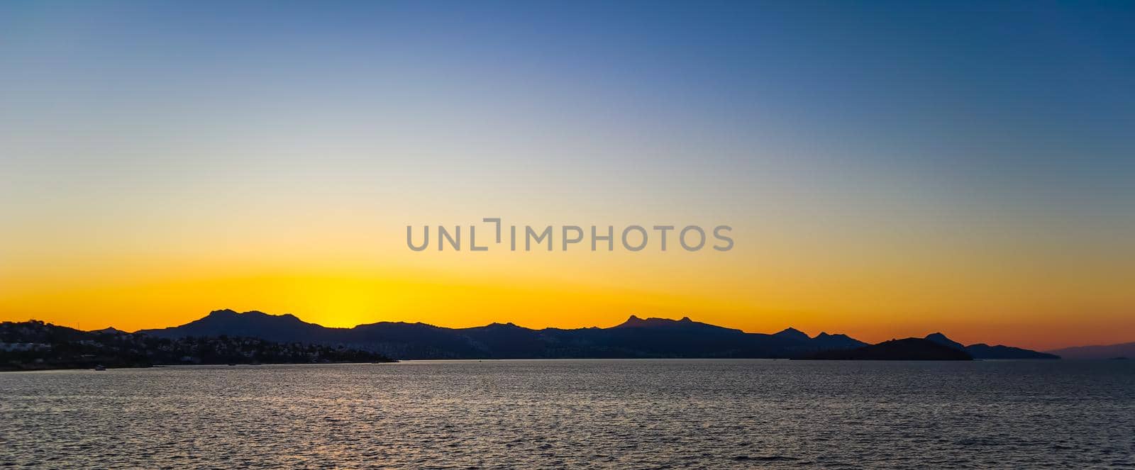 Beautiful bright colorful sunset on the Mediterranean Sea with islands, mountains and boats