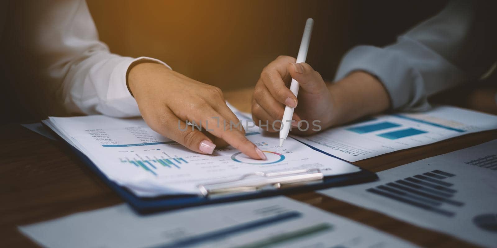 Business people gather in a corporate location to discuss research using paperwork. Concept of a group of businesses cooperating by itchaznong