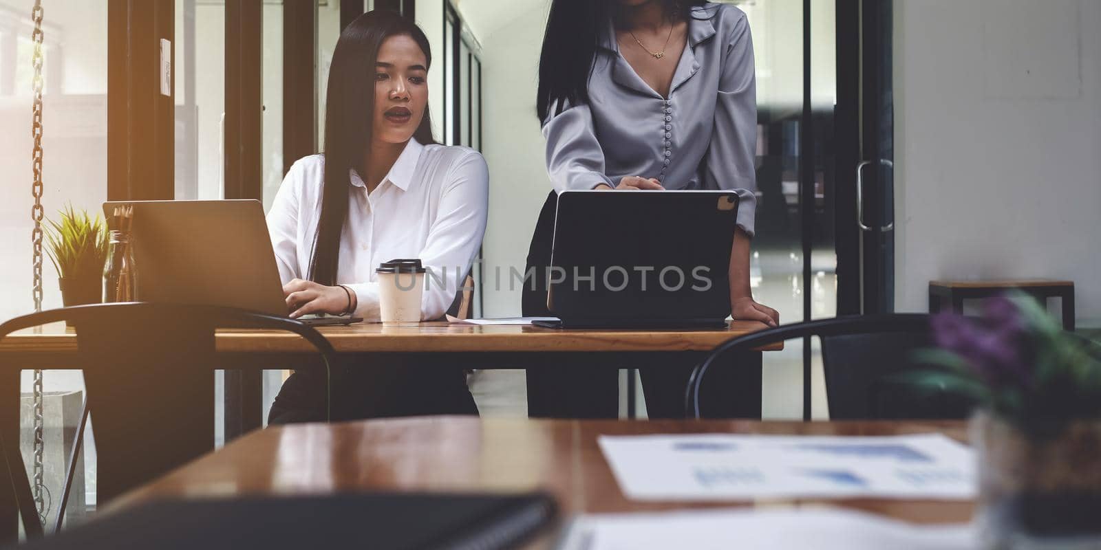 Business people gather in a corporate location to discuss research using paperwork. Concept of a group of businesses cooperating by itchaznong