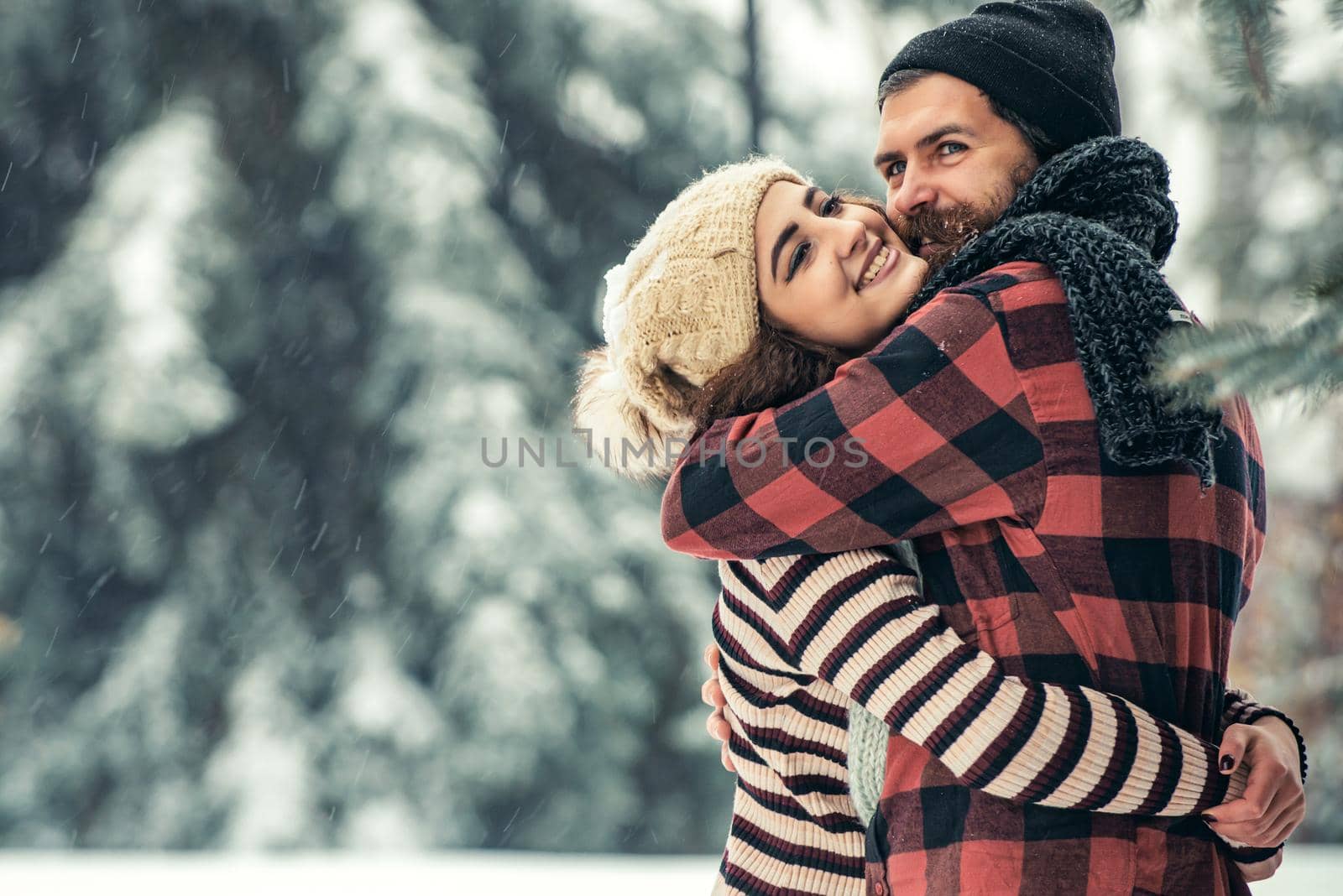 Winter happy couple in love embrace in snowy cold forest, winter holiday love and relations