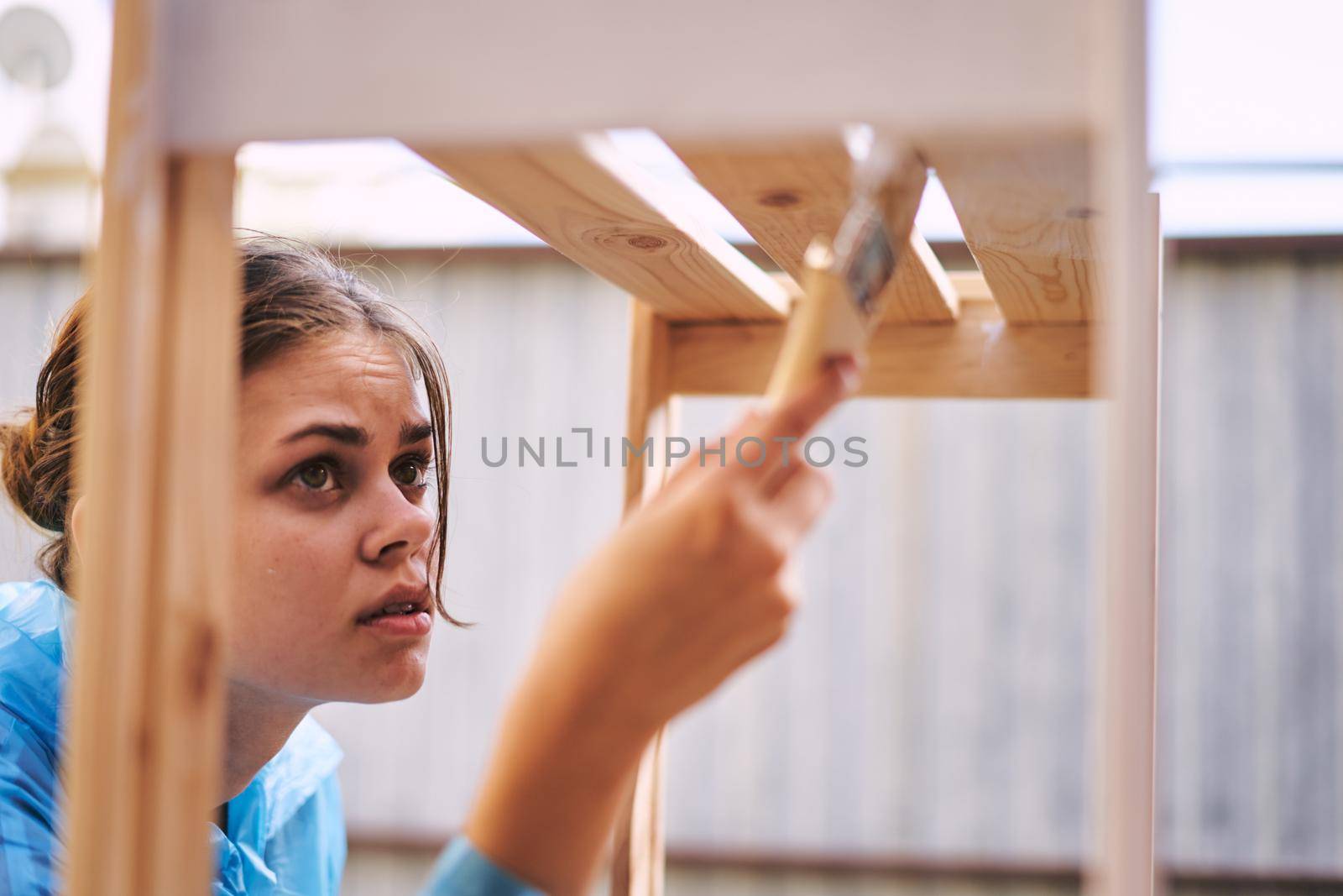 cheerful woman house painter repairing wooden structure. High quality photo