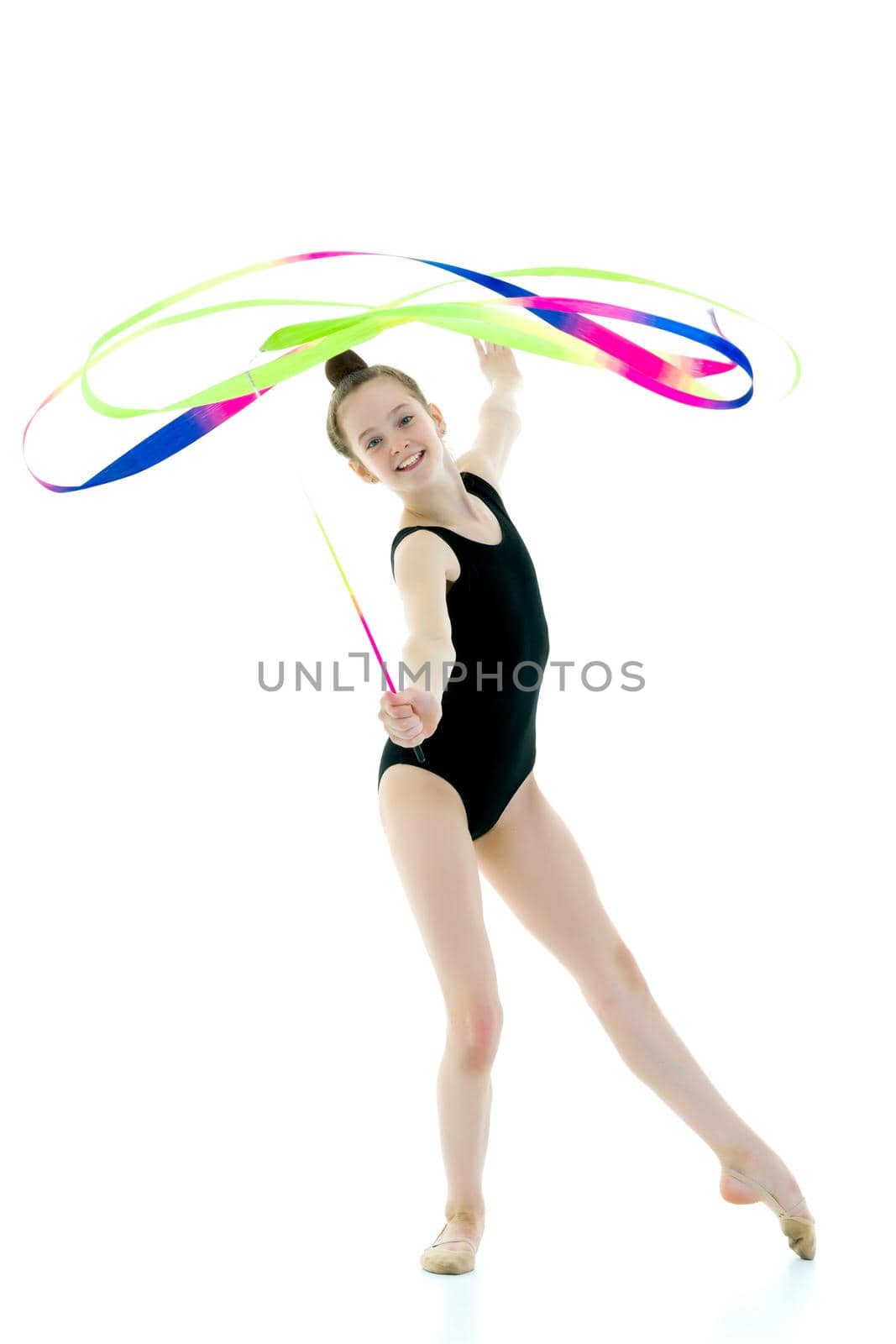 Little girl gymnast performs exercises with tape. The concept of sport, competition. Isolated on white background.
