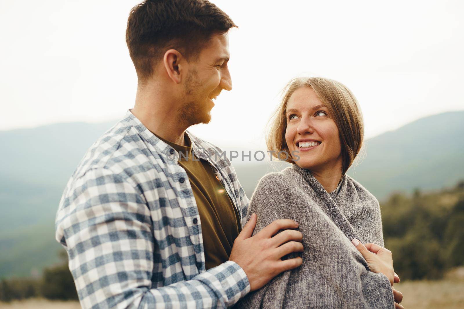 Happy loving couple hiking and hugging in mountains, close up