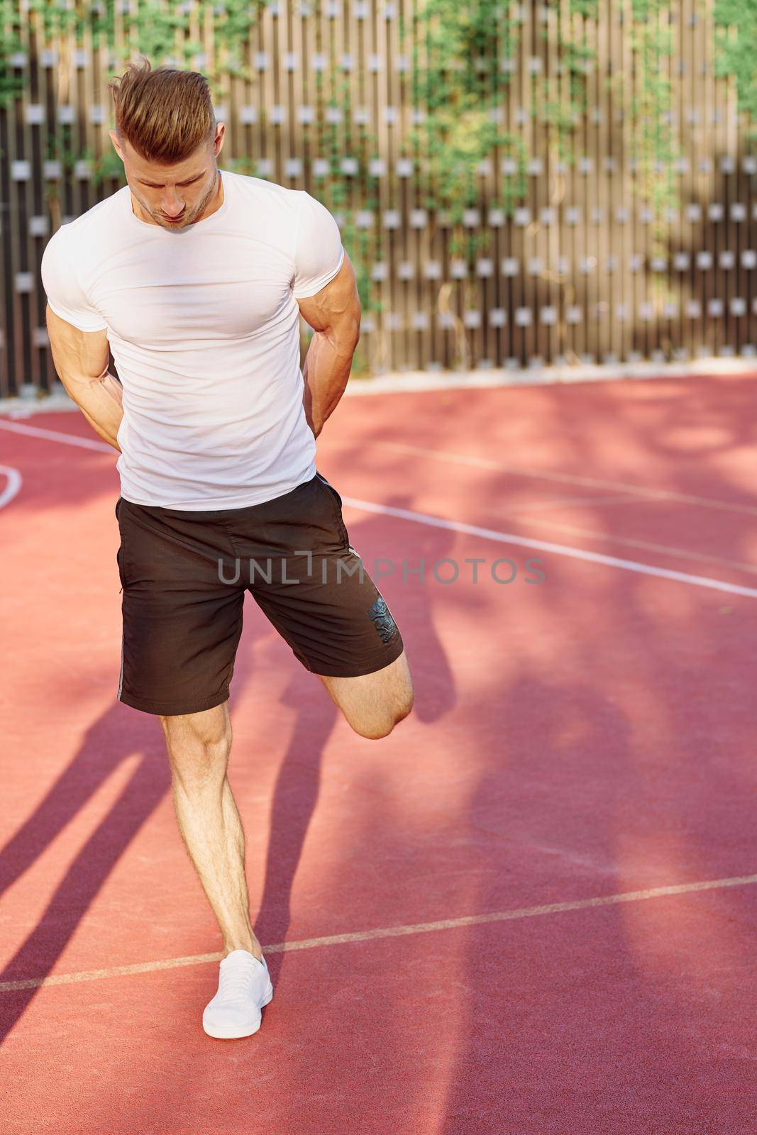 man in white t-shirt on the sports ground workout motivation by Vichizh