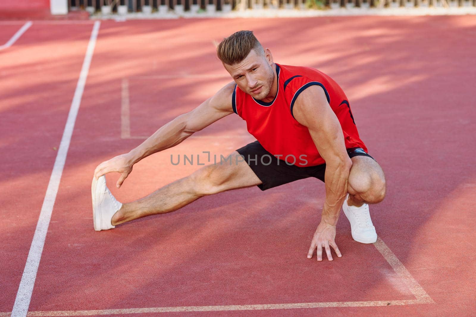 athletic man doing exercises outdoors sports field exercise. High quality photo