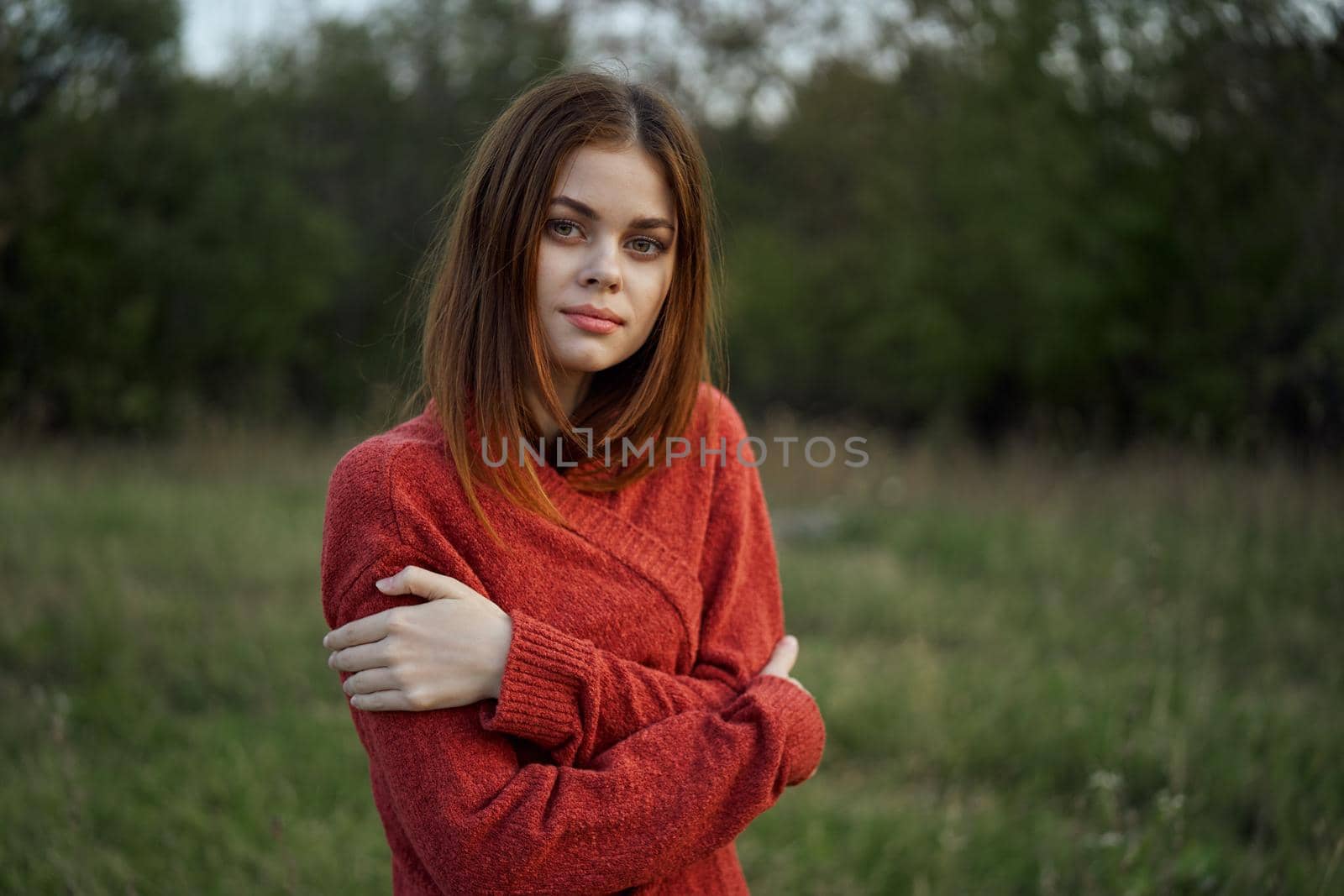 woman in a red sweater outdoors in the field nature rest. High quality photo
