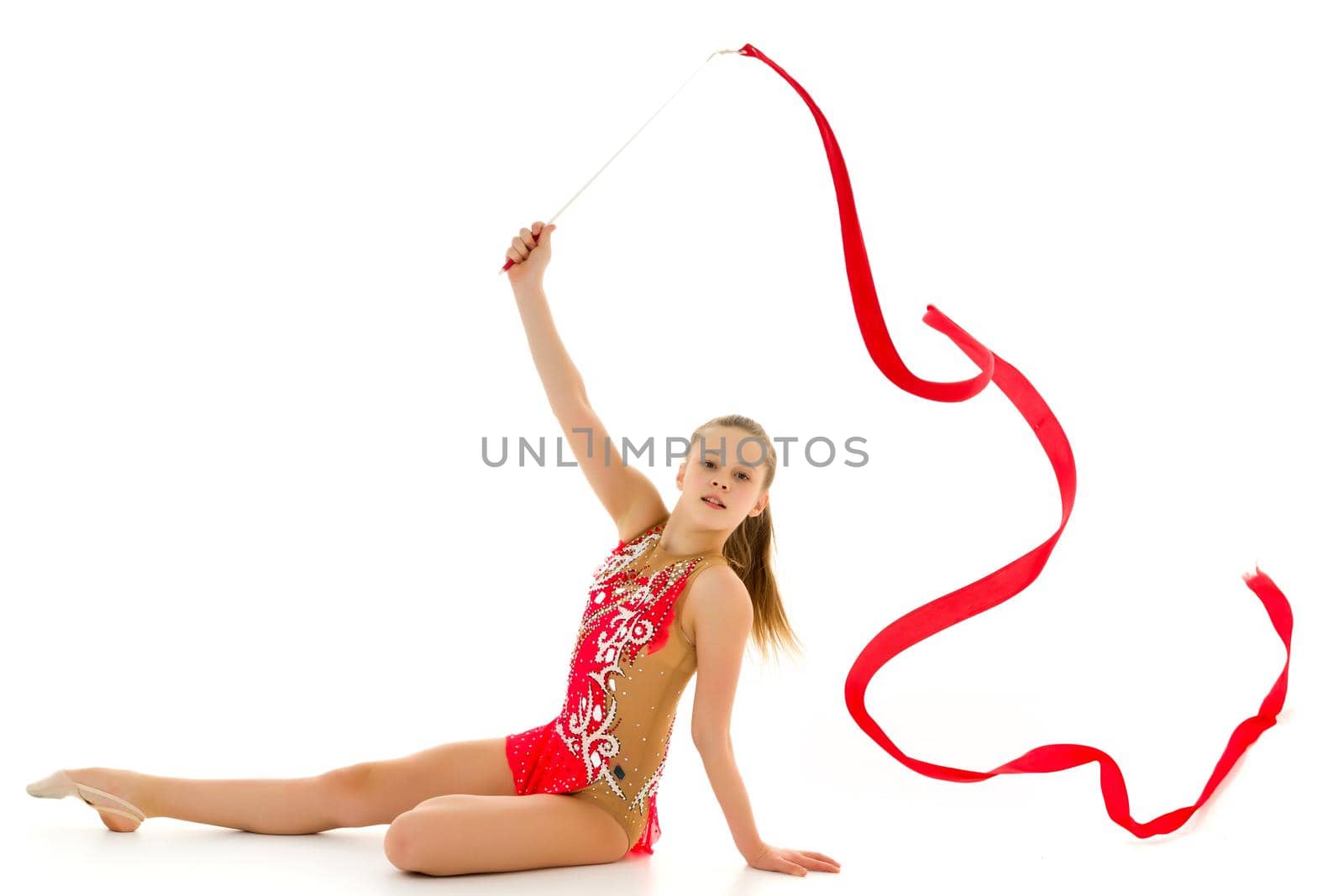 Little girl gymnast performs exercises with tape. The concept of sport, competition. Isolated on white background.