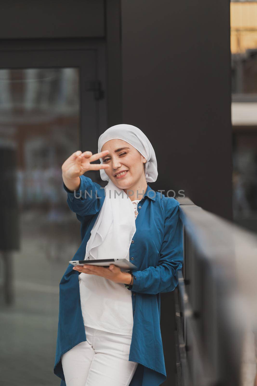 Smiling Asian girl student professional employee holding tablet and sit at outdoor park, happy woman studying e learning online software using technology app for work education.