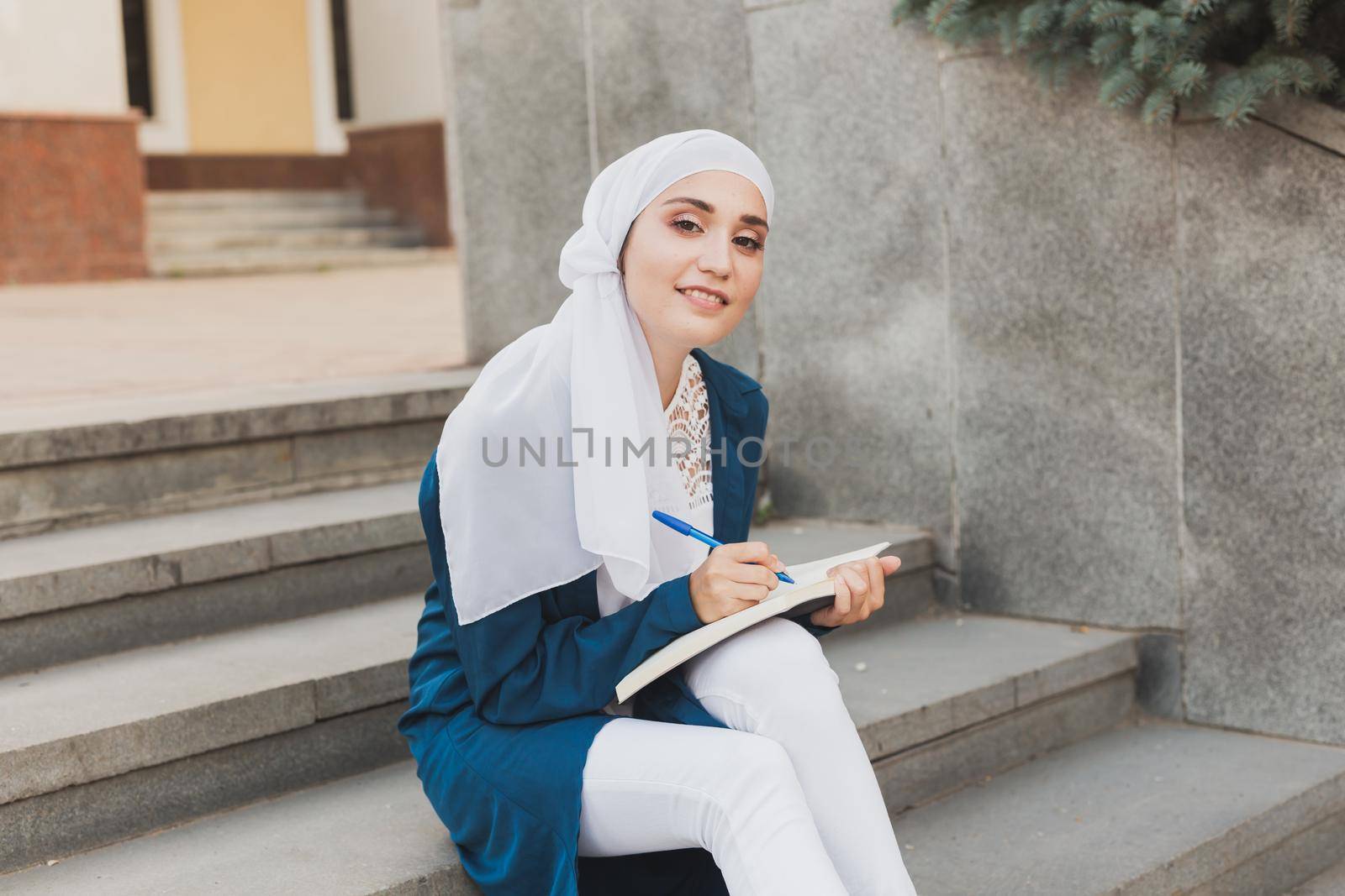 Arab female student sitting on stairs in downtown. by Satura86