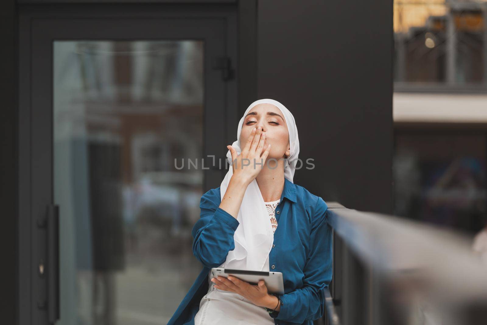 Beautiful Asian businesswomen wearing hijab using her tablet at outdoor and copy space by Satura86