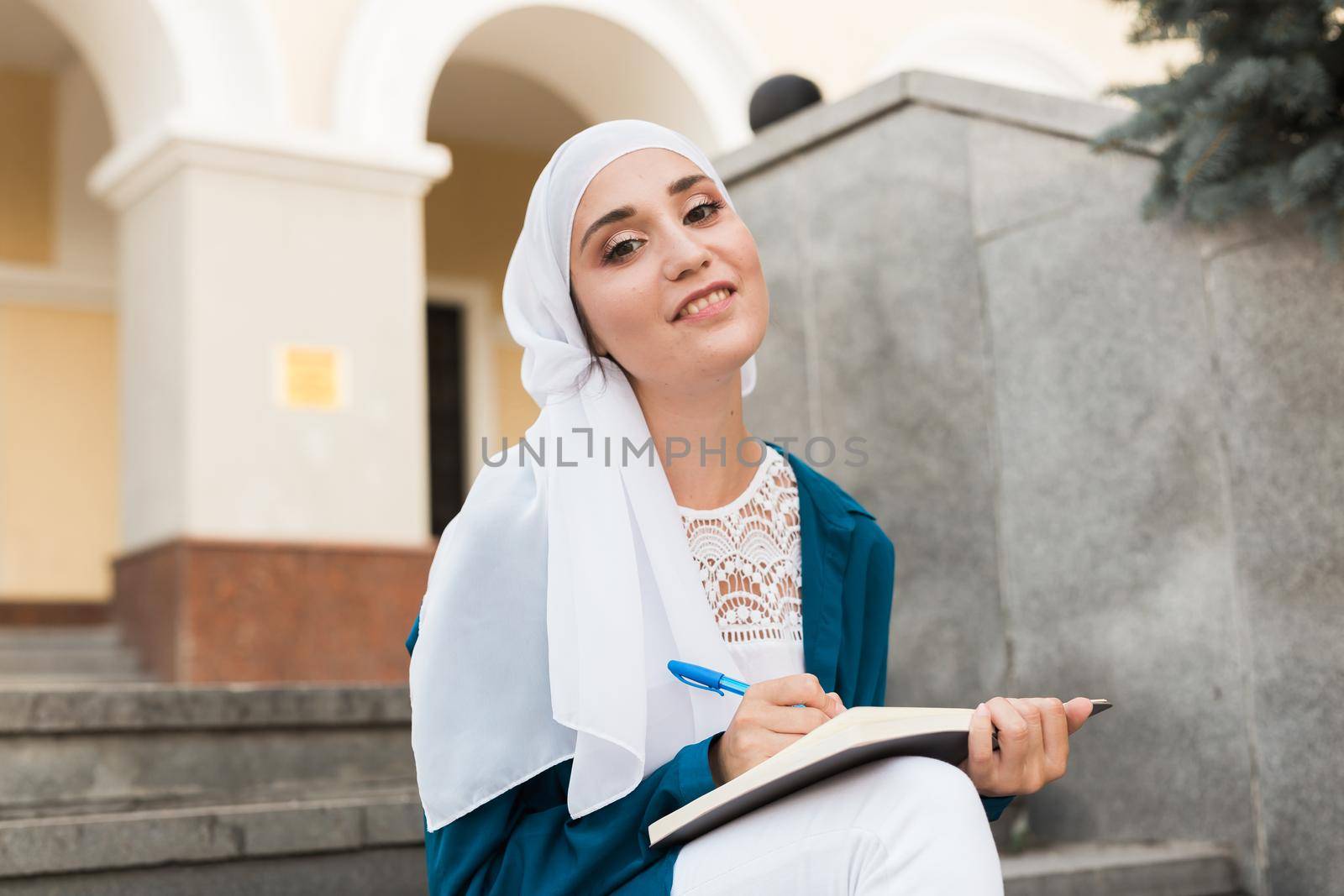 Arab female student sitting on stairs in downtown. by Satura86