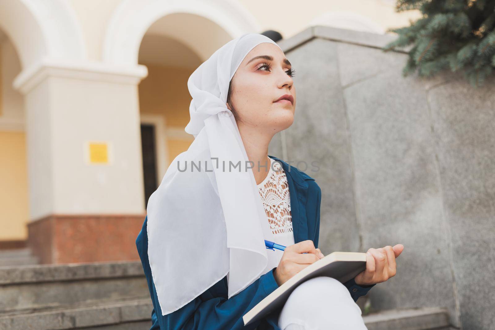 Arab female student sitting on stairs in downtown. by Satura86