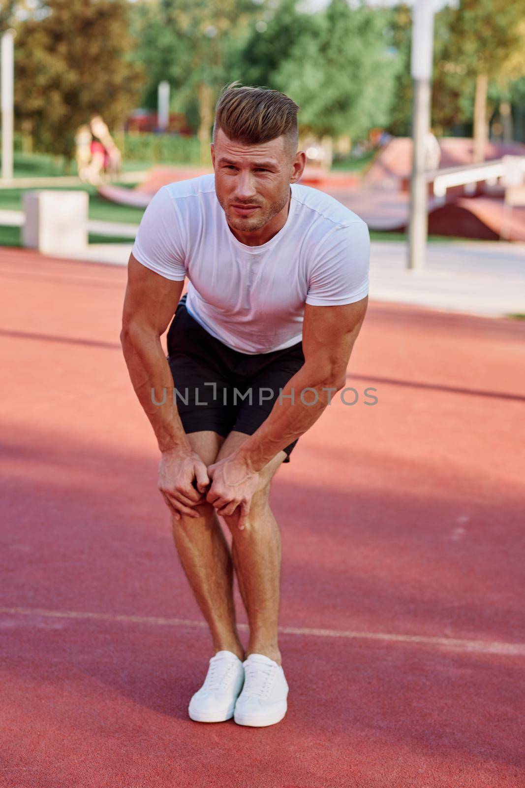 man in white t-shirt on the sports ground workout motivation. High quality photo