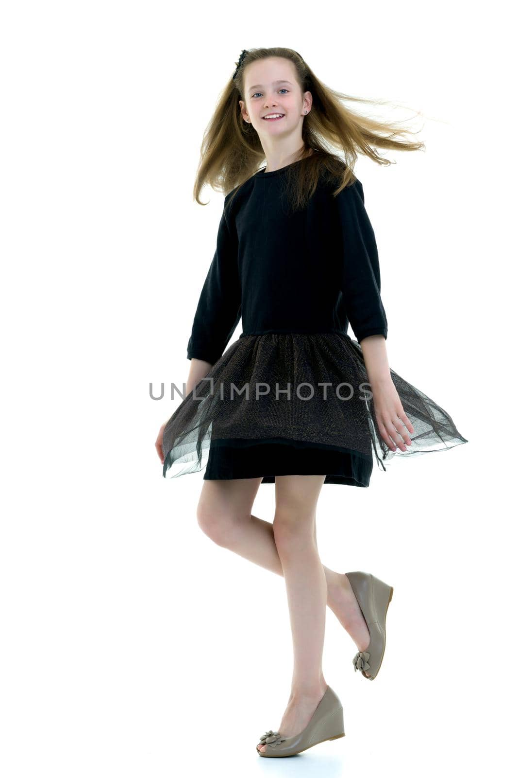 A beautiful little girl stands in the wind, her hair and clothes by kolesnikov_studio