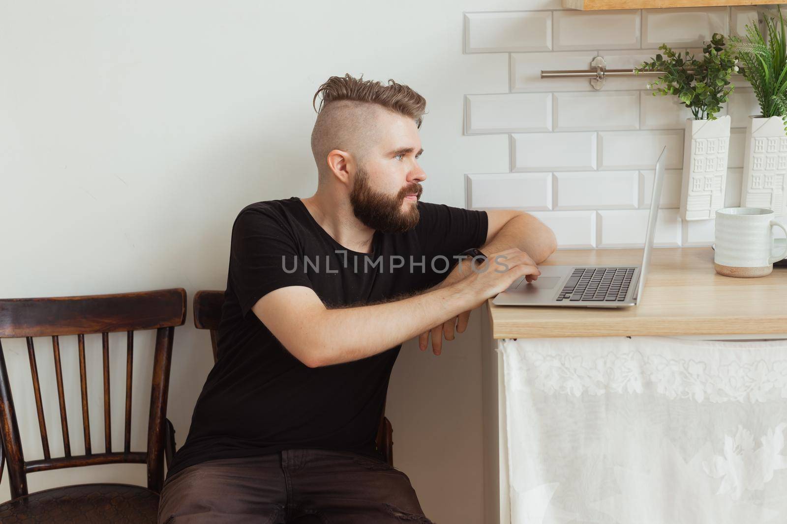 Smiling man working with laptop at home. Technology, home and lockdown concept.