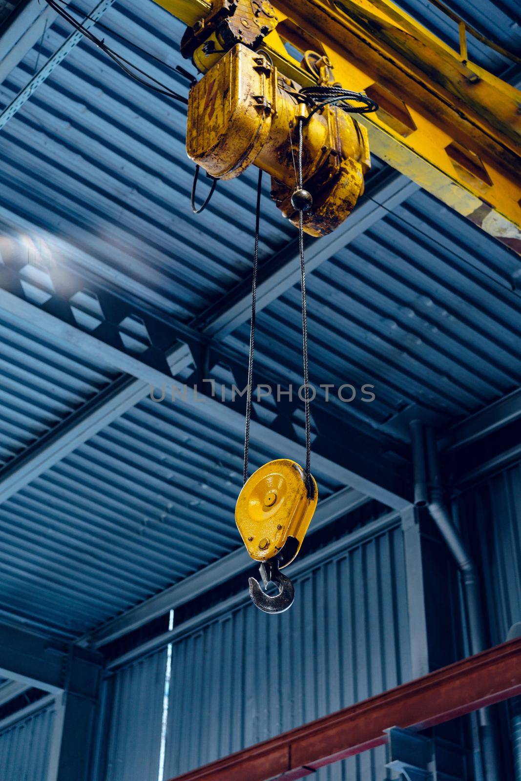 Industrial crane hook in a modern factory building close up